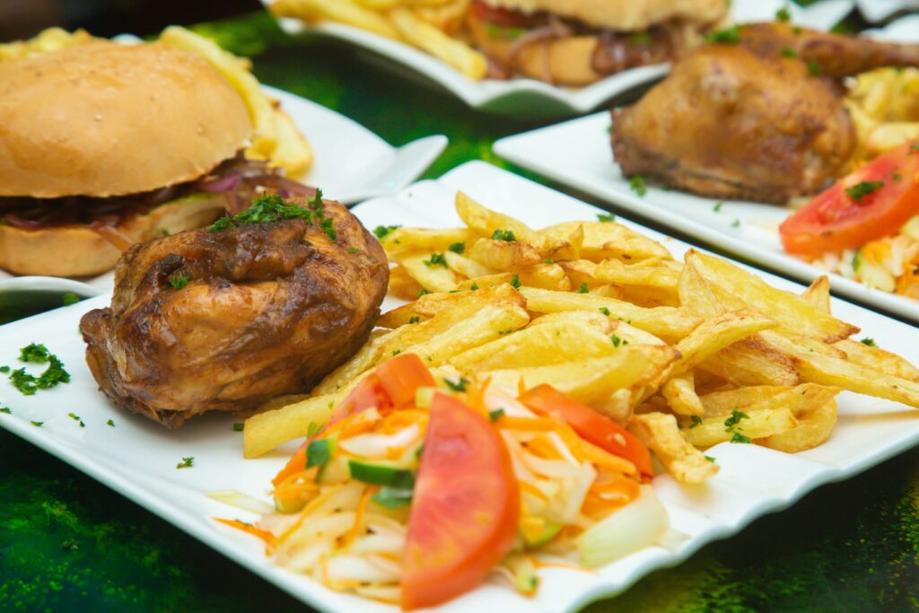 Savory roast chicken with crispy fries and fresh salad on a white plate.