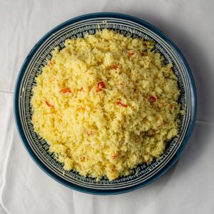 Top view of a plate filled with creamy yellow risotto, garnished with red bell pepper pieces, perfect for food photography.